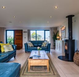 A living room with sofas and a coffee table at Trevelyan in Marhamchurch