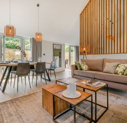 A living room with a sofa and dining table at Gwari Spa Barn 3.0 in Marhamchurch