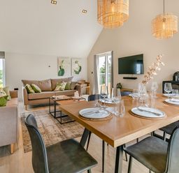 A living room with a sofa, dining area and television at Gwari Spa Barn 3.0, Marhamchurch