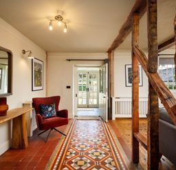 An entryway with a chair and table at Whalesborough Farmhouse Spa in Marhamchurch