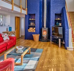 A living room with a fireplace and television at Calf House Spa Marhamchurch