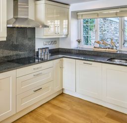 A kitchen with a sink and cabinets at Calf House Spa Marhamchurch