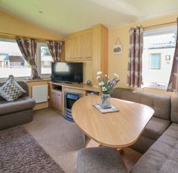A living room with a TV and a coffee table at Caravan 2 at Blackmoor Farm near tenby