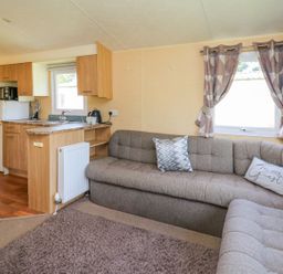 A living room with a sofa and kitchen area at Caravan 2 at Blackmoor Farm near tenby