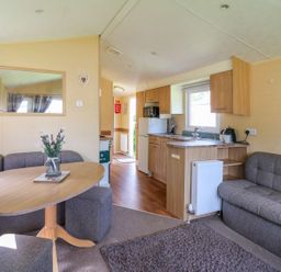 A living room with seating and kitchen area at Caravan 2 at Blackmoor Farm near tenby