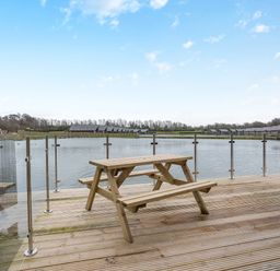 An outdoor area with a table by the water at Tranquillity 4 (Pet) in Carnforth