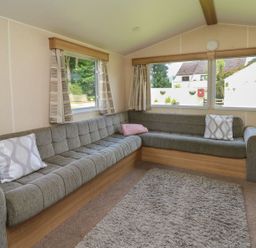 A living room with a sofa and windows at Caravan 3 at Blackmoor Farm near tenby