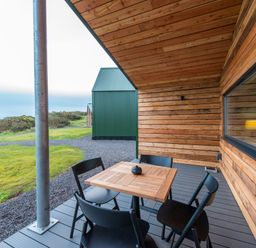 A wooden table with black chairs on a patio at The Telfer in North Berwick