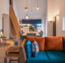 A living room with a sofa and dining area at The Telfer in North Berwick