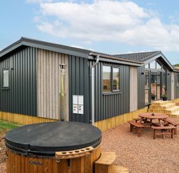 A modern cabin with a hot tub and outdoor seating at The Townsend in North Berwick