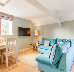 A living room with a sofa and dining area at Crabtree Cottage in Bude