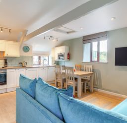 A kitchen with a sofa and dining area at Crabtree Cottage in Bude