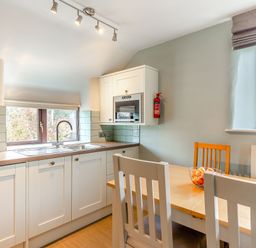 A kitchen with a sink and dining area at Crabtree Cottage in Bude