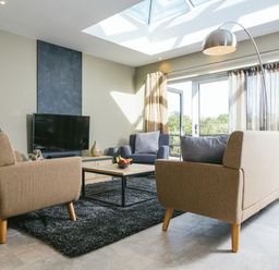 A living room with a sofa and television at Cornish Lodge Spa in Bude