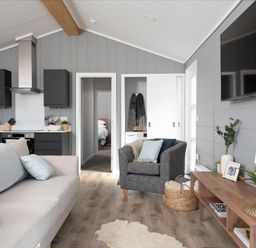 A living room with sofa and armchair at Kynance Spa (Pet) in Bude