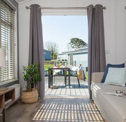 A living room with a sofa and a table at Kynance Spa in Bude