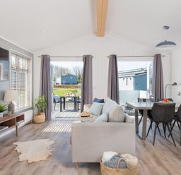 A living room with a sofa and dining area at Kynance Spa in Bude