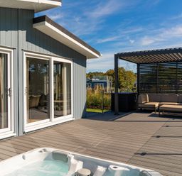 An outdoor area with a hot tub and seating at Mullion 2 Spa in Bude
