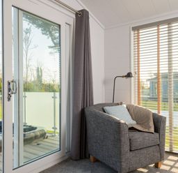 A snug with a sofa and a window at Mullion 2 Spa in Bude