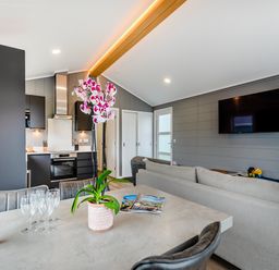 A living room with a dining table and kitchen area at Kynance (Pet) in Bude