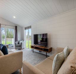 A living room with a sofa and television at Mullion 2 Spa (Pet) in Bude