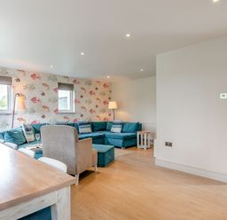 A living room with a sofa and lamp at Summerleaze Garden Cottage 3 Spa in Bude
