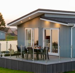 A building with a deck and dining setup at Mullion Spa in Bude