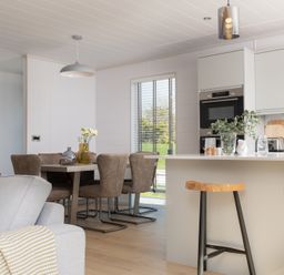 A kitchen with a table and chairs at Sennen 3 Spa Roof Terrace Bude