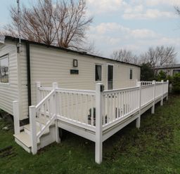 A mobile home with a deck and railing at Willerby Ellerrton (delyn)