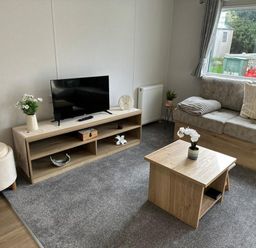 A living room with a television and coffee table at Willerby Ellerrton (delyn) Prestatyn