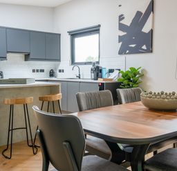 A kitchen with cabinetry and dining area at Cabin 2.0 in Dumfries