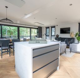 An open plan living space with a kitchen island and dining area at Cabin 2.0 in Dumfries