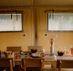 A dining room with a table set with food at Standard Safari Tent in Fair Oak