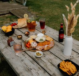 A wooden table with food and drinks at Standard Safari Tent Fair Oak