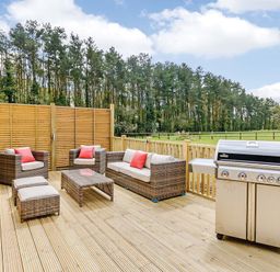 An outdoor seating area with furniture and a barbecue grill at Lancaster Lodge Fair Oak