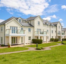 A building with balconies and windows surrounded by grass at 8 Thurlestone Beach in Kingsbridge