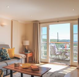 A living room with a couch and table at 8 Thurlestone Beach in Kingsbridge