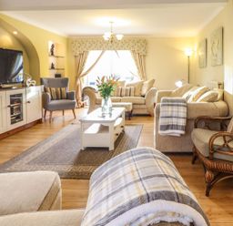 A living room with a television and sofas at Llwyn Derw in Talybont