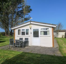 A chalet with a patio and seating area at Chalet 225 Tregolds near St Merryn
