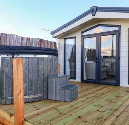 An outdoor area with a hot tub and steps at Rosefinch Cabin Scarborough