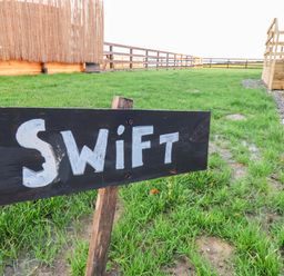A sign labeled Swift in a grassy area at Swift Cabin in Scarborough