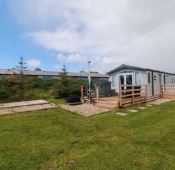 A cabin with a deck and hot tub at Swift Cabin Staintondale near Scarborough