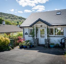 A house with a garden and driveway at Oaks Lodge Cottage in Ambleside