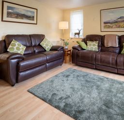 A living room with two sofas and a lamp at Oaks Lodge Cottage in Ambleside