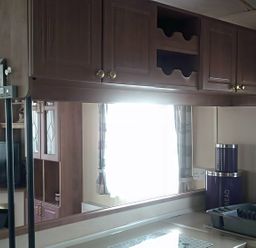 A kitchen with cabinets and a television at Coopers Beach Holiday Park - Holiday Accommodation 3999 Mersea Island