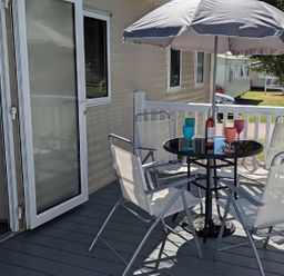 A deck with a table and chairs at Coopers Beach Holiday Park - Holiday Accommodation 6404 Mersea Island