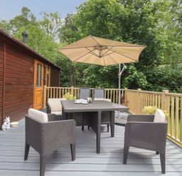 A outdoor seating area with a table and chairs at Kingfisher Lodge in Windermere