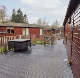 An outdoor area with decking and a table at Kingfisher Lodge in Grasmere 33, White Cross Bay near Windermere