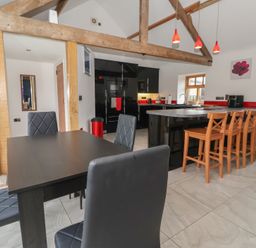 A kitchen with a dining area and bar stools at Pillar Barn Driffield