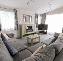 A living room with a sofa and television at Beechwood Lodge